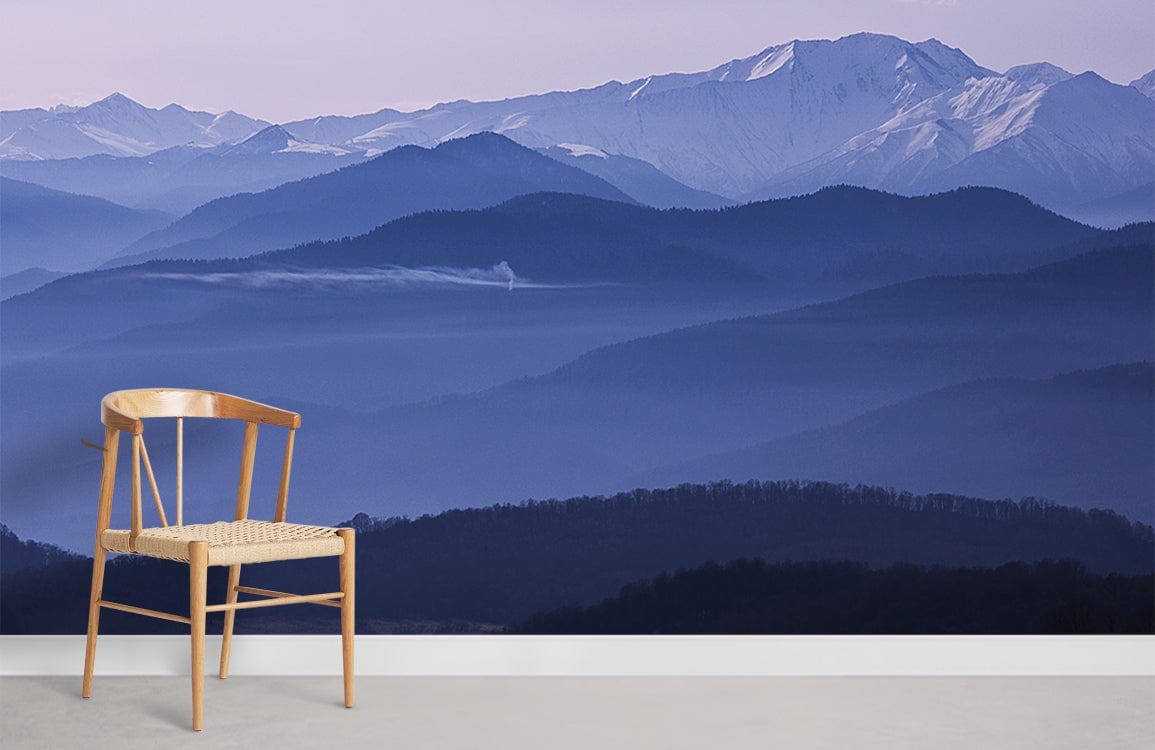 Serene Mountain Mist Blue Mural Wallpaper features chair, light flooring in tranquil interior setting.