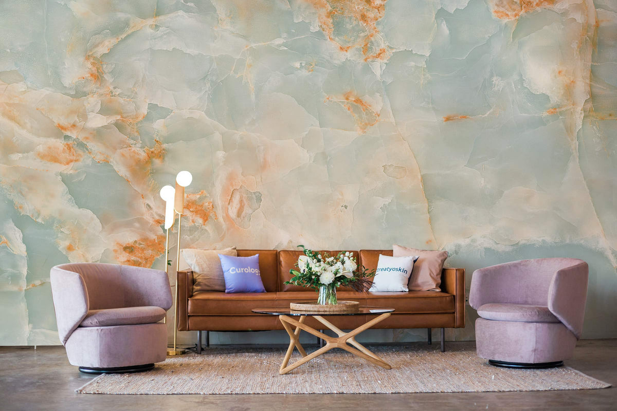 Luxurious ethereal marble effect mural wallpaper, aqua and coral hues, brown sofa, modern chairs, chic decor.