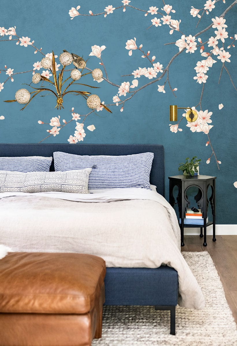 Elegant Blue Cherry Blossom Bird Mural Wallpaper in bedroom with blue bed and leather ottoman.