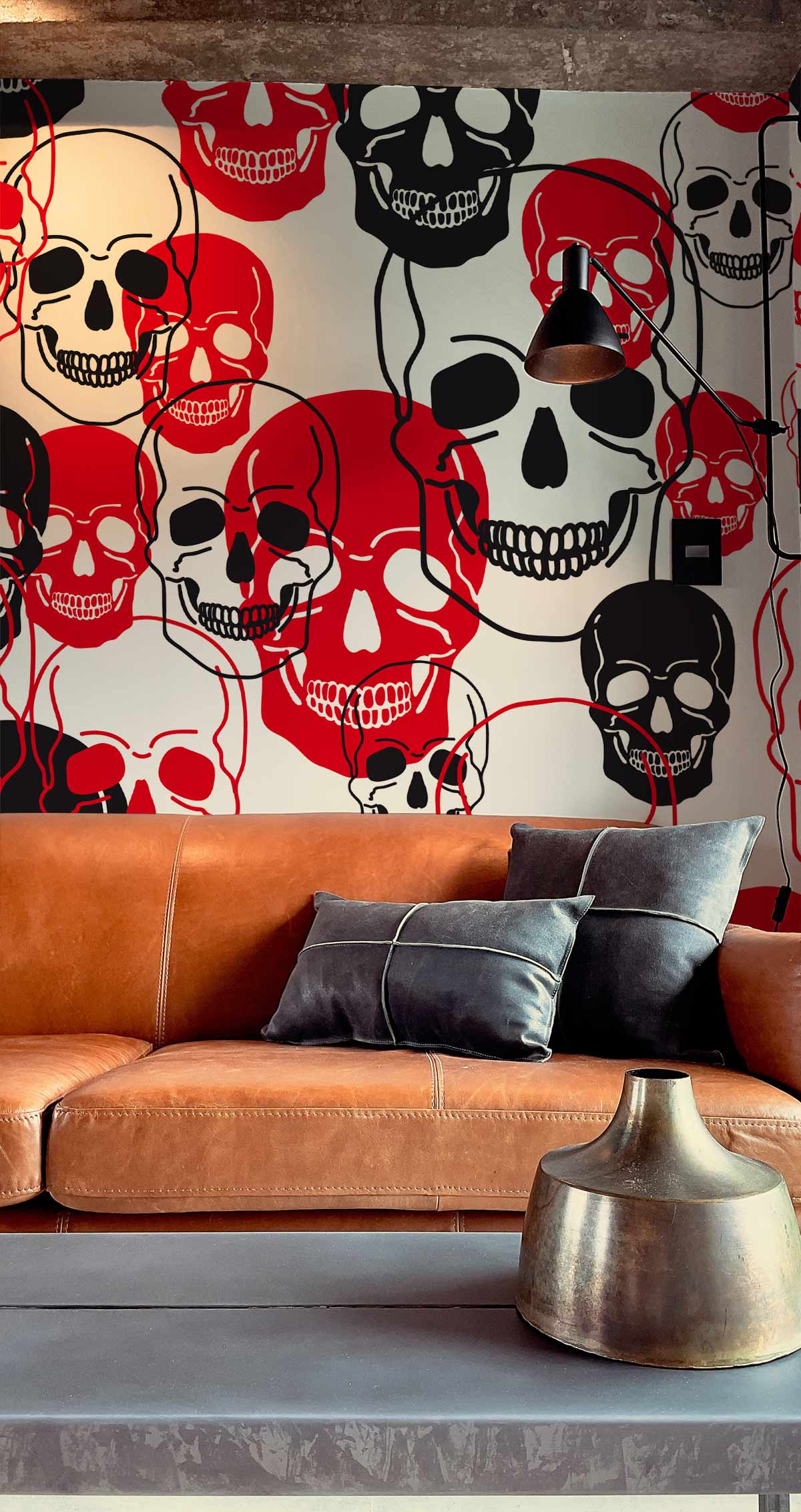Graphic wallpaper with red and black skulls, modern brown leather sofa, metal pendant light, industrial decor.