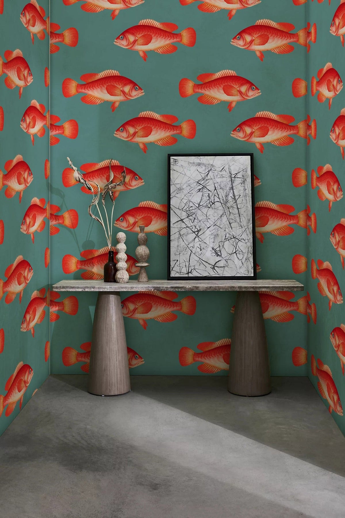 Vibrant red fish wallpaper in coastal-themed room, featuring sleek console table on concrete floor.