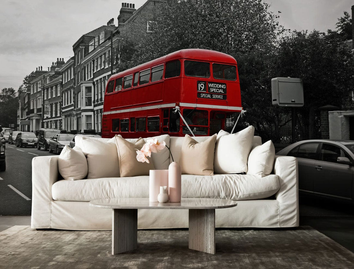Vintage London red bus wallpaper in urban scene, featuring white sofa, wooden table, neutral flooring.