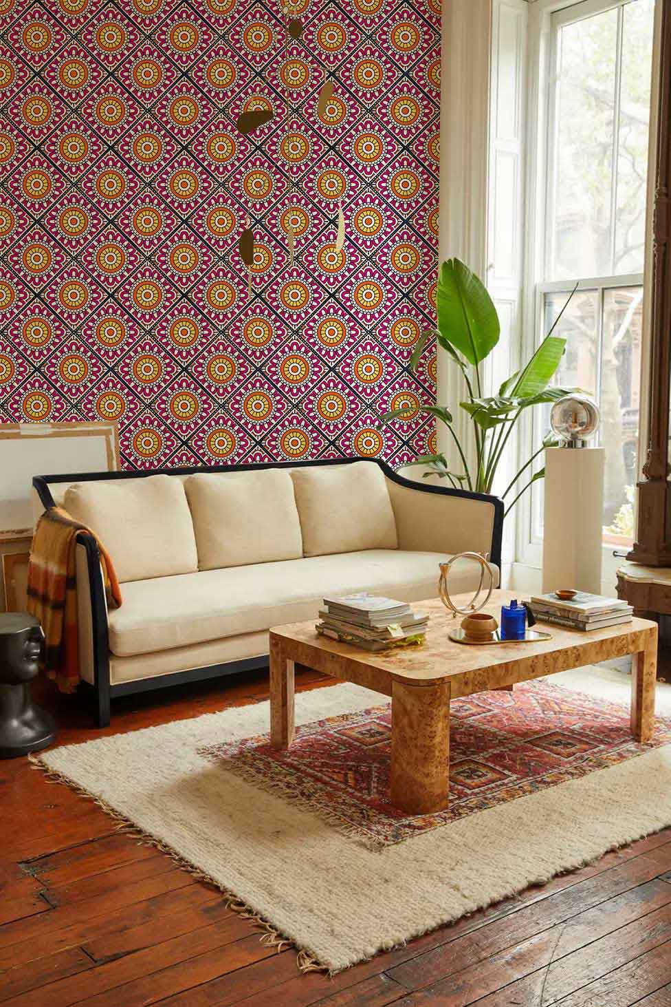 Vibrant retro geometric wallpaper in living room with cream sofa, wooden flooring, and stylish decor.