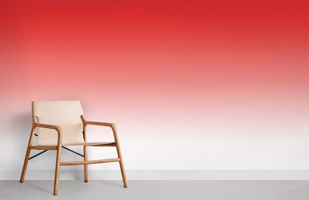 Vibrant red-to-white gradient ombre wallpaper with wooden chair on grey flooring in modern room.