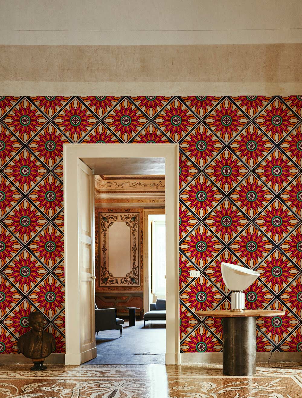 Vibrant wallpaper in bold red-orange geometric floral pattern with stylish side table in elegant room.