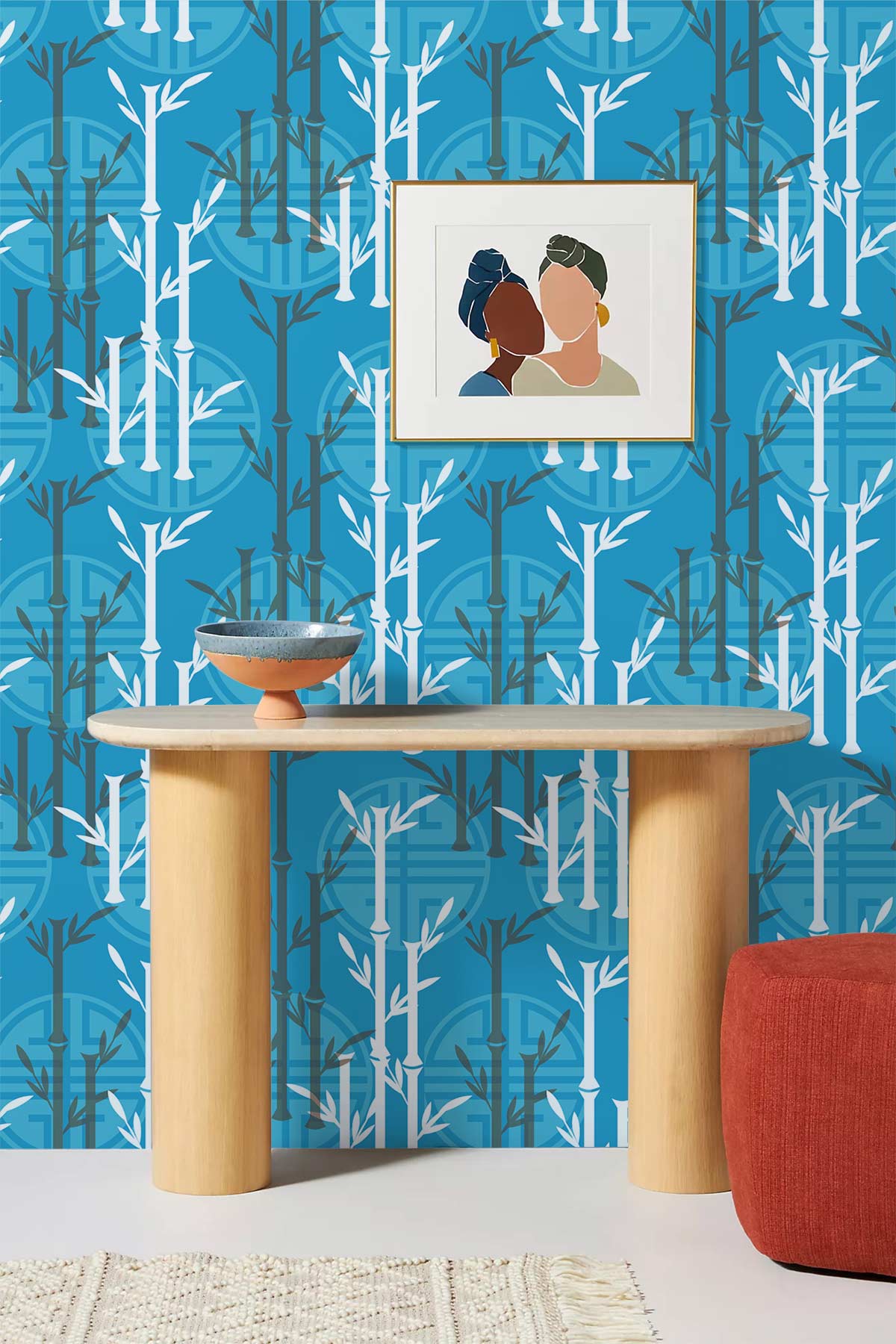 Bamboo Forest teal wallpaper with minimalist bamboo design, wooden console, red ottoman, framed abstract art.
