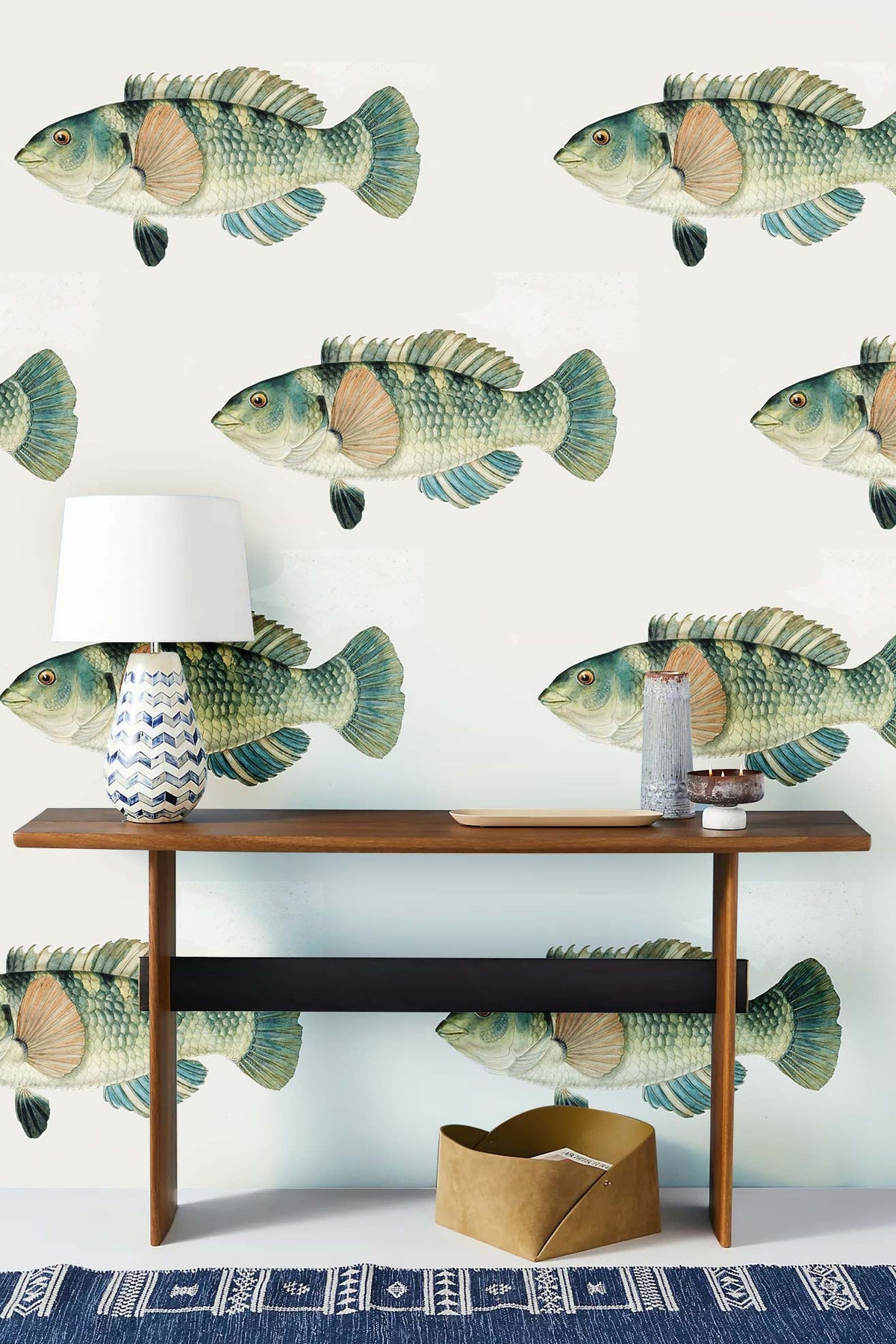 Vintage fish pattern wallpaper in soft green behind wooden console table, coastal retreat Décor style.