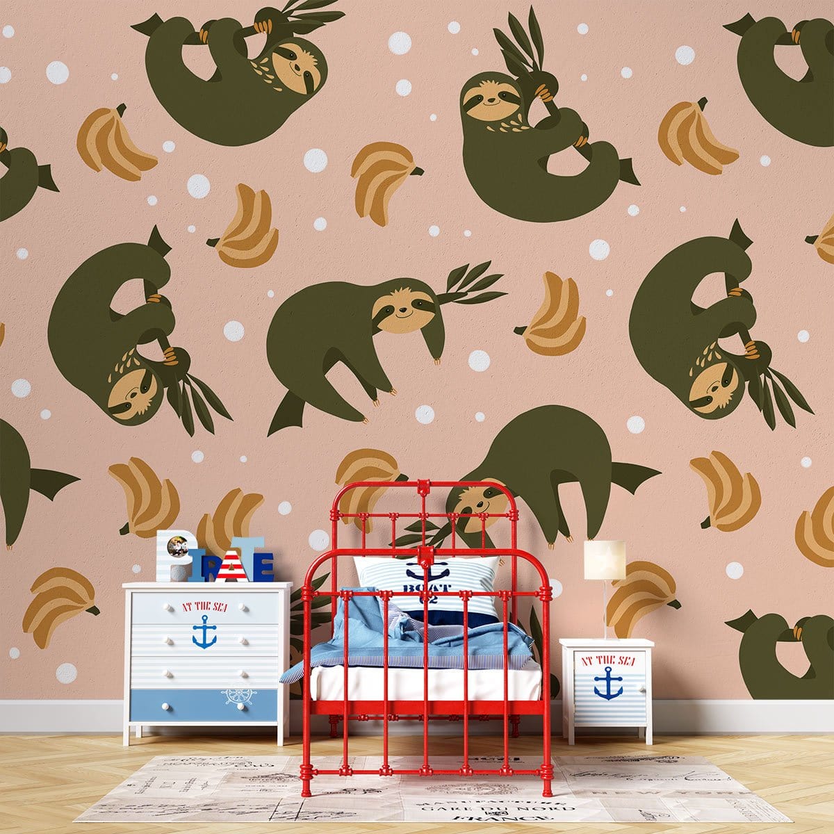 Green and peach sloth wallpaper in child's room with red bed, nautical dresser, wooden flooring.