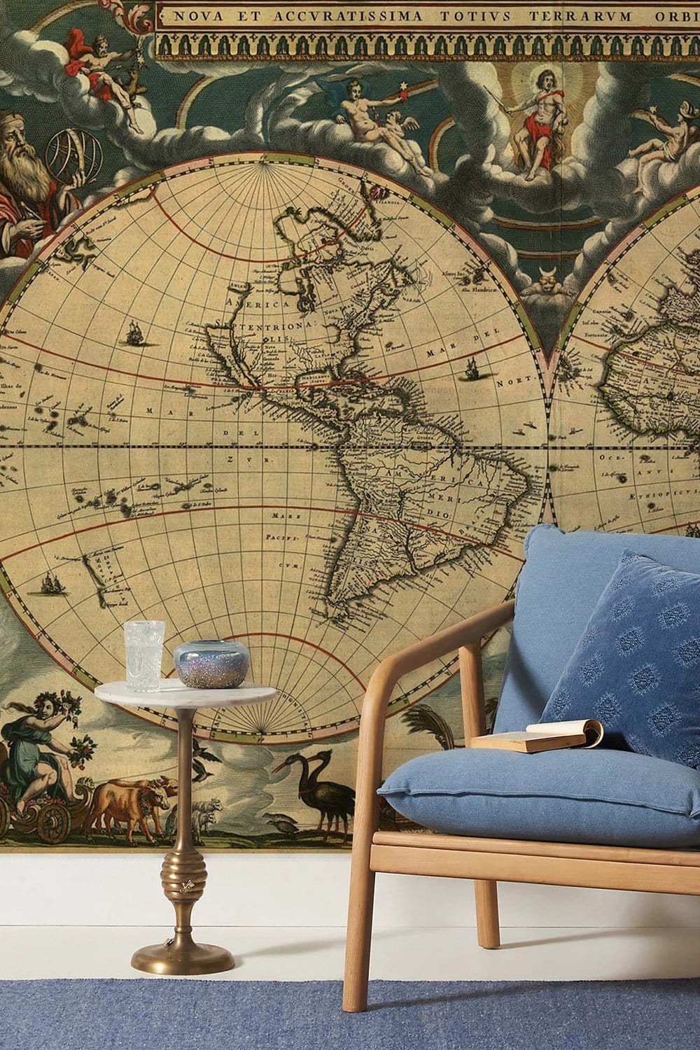 Antique World Map Mural Wallpaper with vintage style, blue sofa, brass side table, in living room.