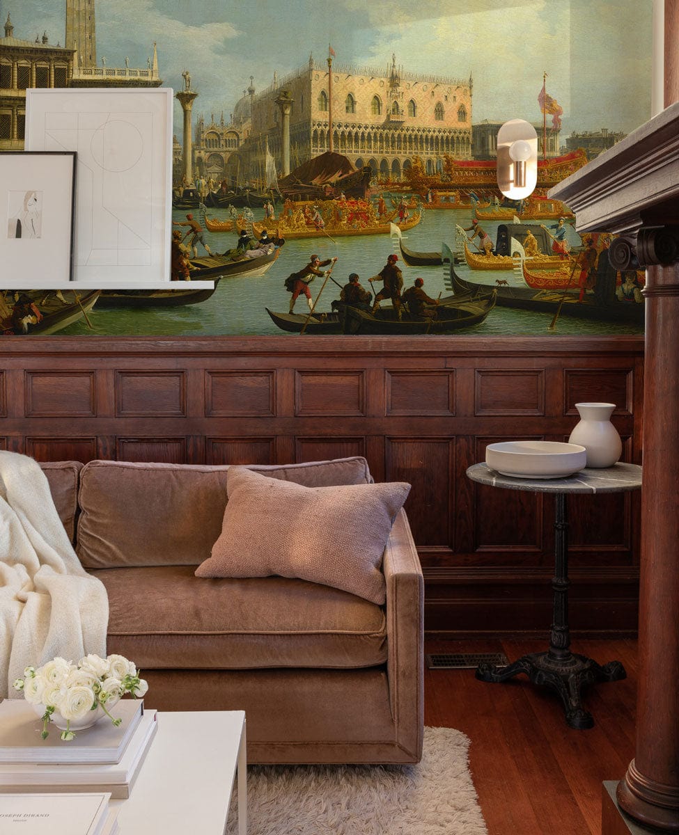 Historic Venetian canal mural wallpaper in living room, brown sofa, dark wood panelling, elegant decor.