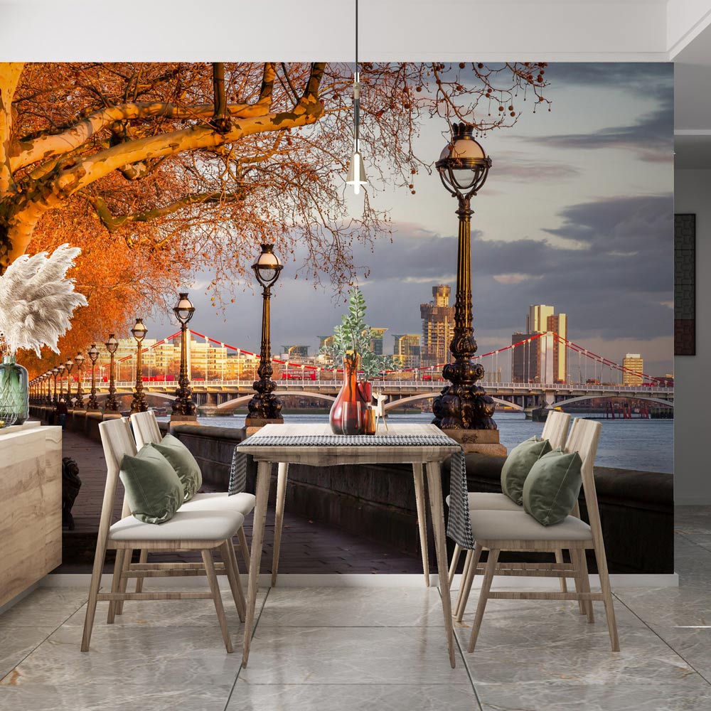 Dining room with Golden Hour River Thames mural wallpaper, wooden chairs, grey cushions, marble flooring.