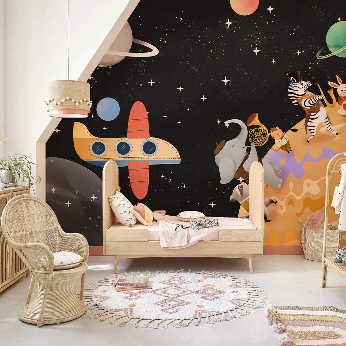 Whimsical space adventure animal mural wallpaper in vibrant children's bedroom with wicker furniture and rug.