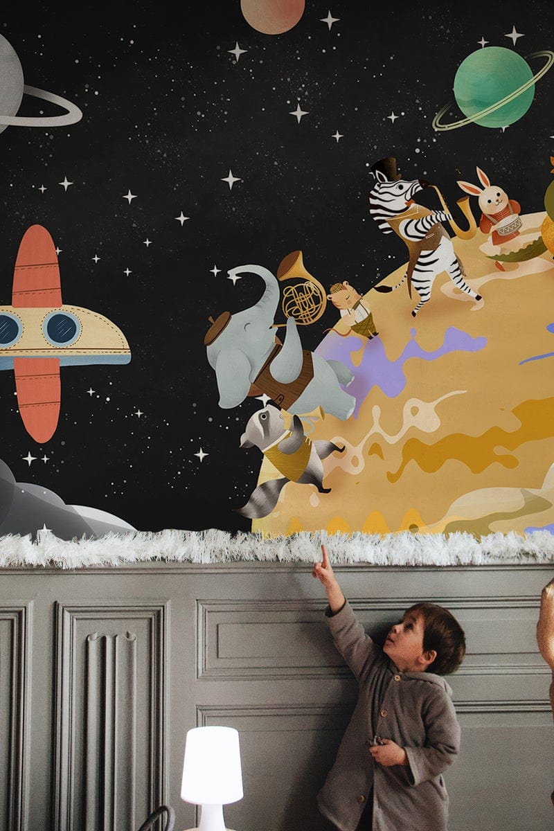 Animal mural wallpaper in children's bedroom with grey panelled walls, playful space theme decor, white lamp.
