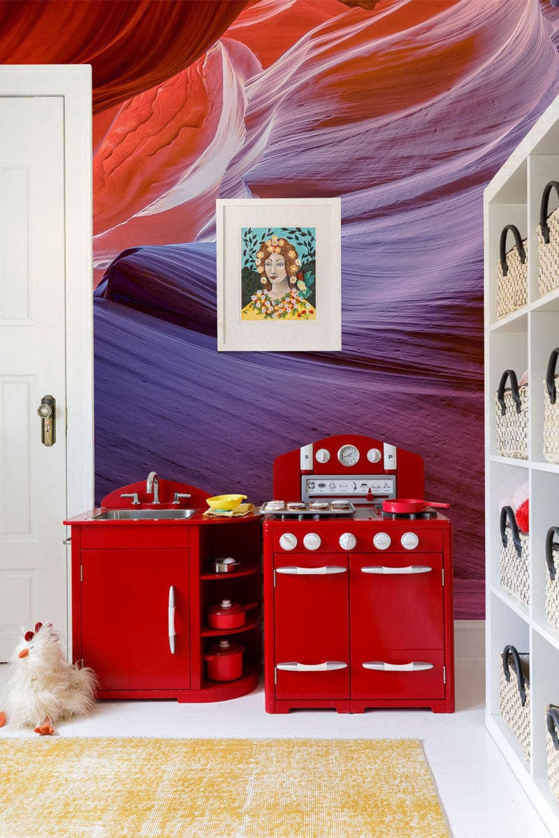 Children's room with Elegant Canyon Drape Mural Wallpaper, vibrant red play kitchen, white shelf, yellow rug.