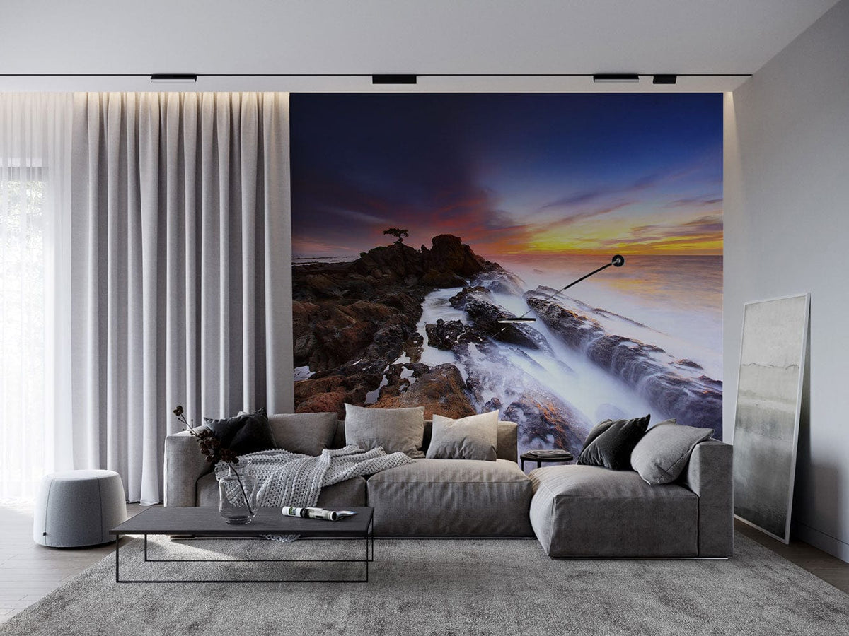 Sunset Seascape Mural: Tranquil Coastal View in living room with grey sofa, curtains, modern decor.