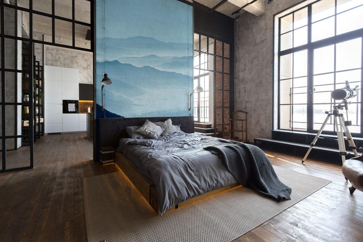 Industrial bedroom featuring Tranquil Blue Misty Mountains scenic mural, grey bed, telescope, hardwood flooring.