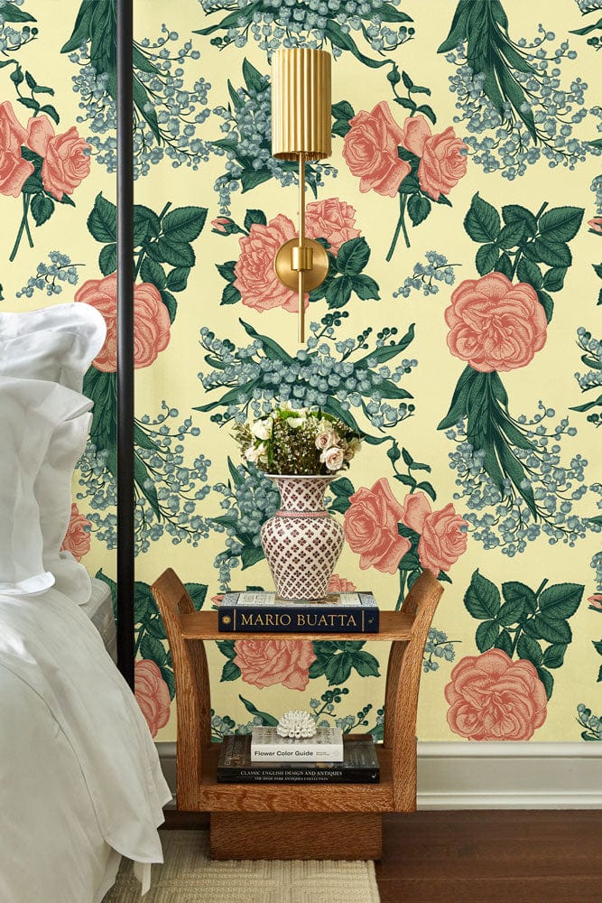 Vintage floral wallpaper with pink and green palette in bedroom featuring rustic wood bedside table.