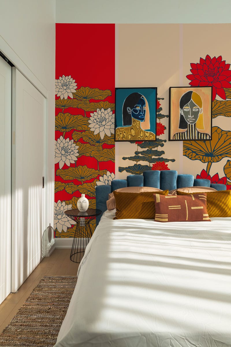 Red and gold oriental wallpaper mural features floral design in modern bedroom with blue headboard.