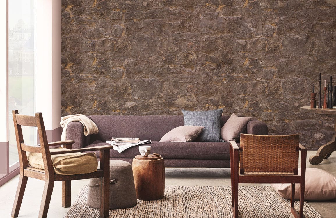 Rustic brown stone brick wallpaper, classic interior decor with brown sofa, wooden chairs, textured rug.