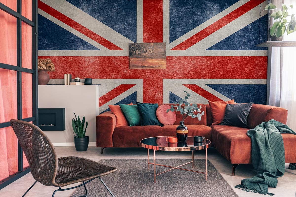 Vintage Union Jack mural wallpaper in living room with rust sofa, modern furniture, and industrial decor.