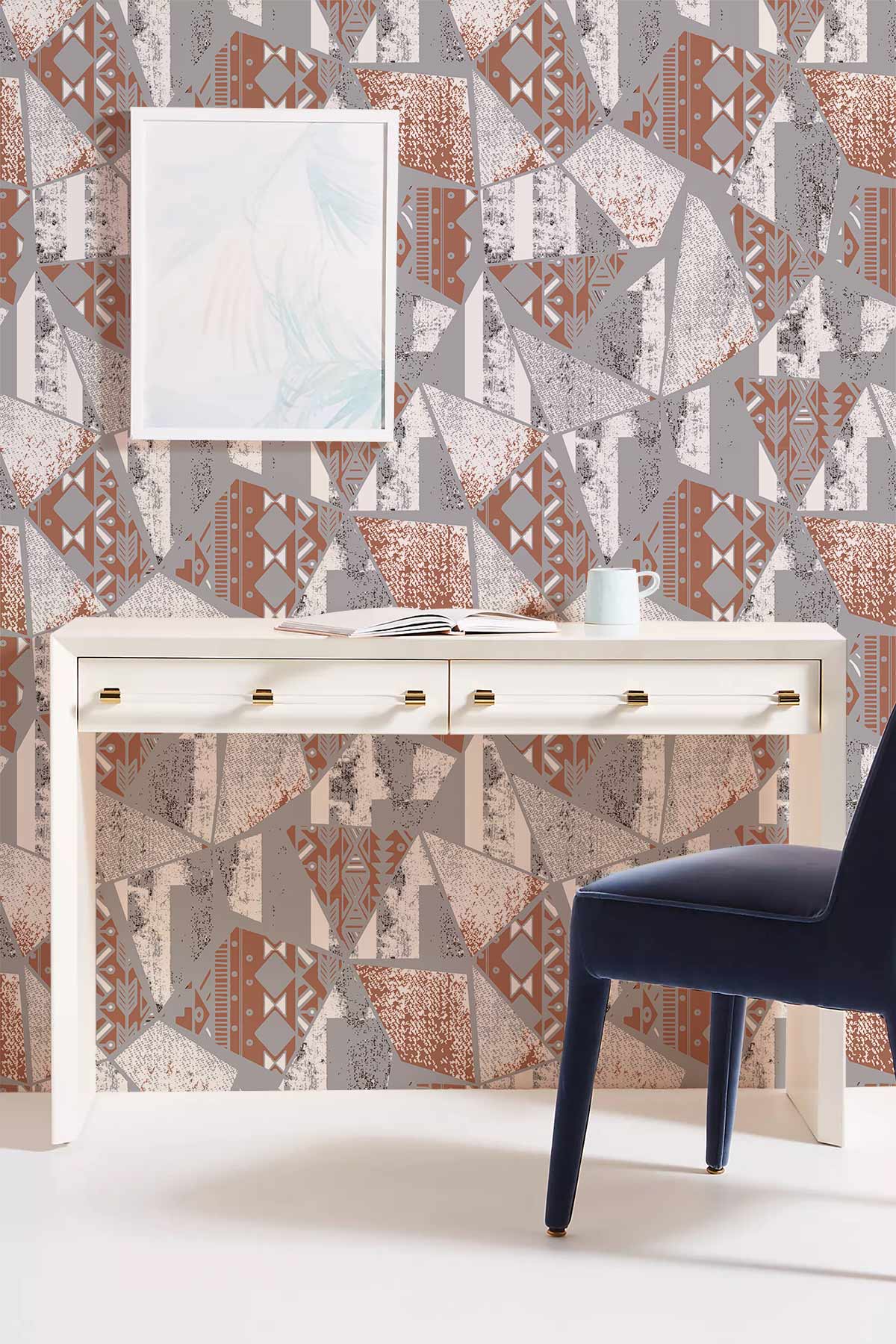 Abstract geometric terracotta wallpaper in modern interior, featuring white desk and dark blue chair.