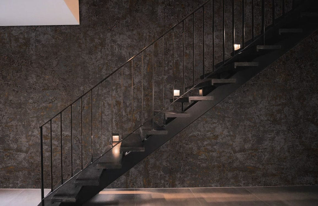 Rustic Industrial Charcoal Textured Mural Wallpaper in modern staircase setting, sleek metal railing, grey flooring.