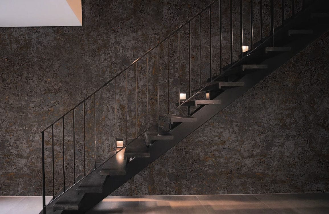 Rustic Industrial Charcoal Textured Mural Wallpaper in modern staircase setting, sleek metal railing, grey flooring.
