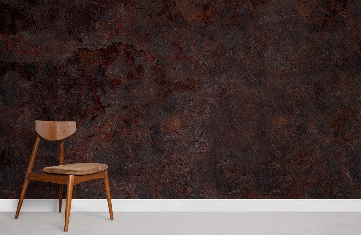Rustic industrial dark brown textured stone effect wallpaper with wooden chair, white skirting, concrete floor.