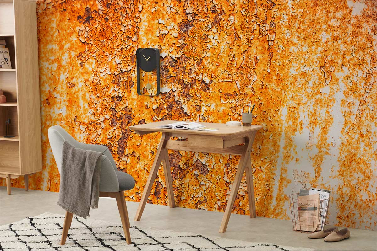 Stylish room with vintage rust wall mural, modern armchair, wooden desk, and geometric rug.