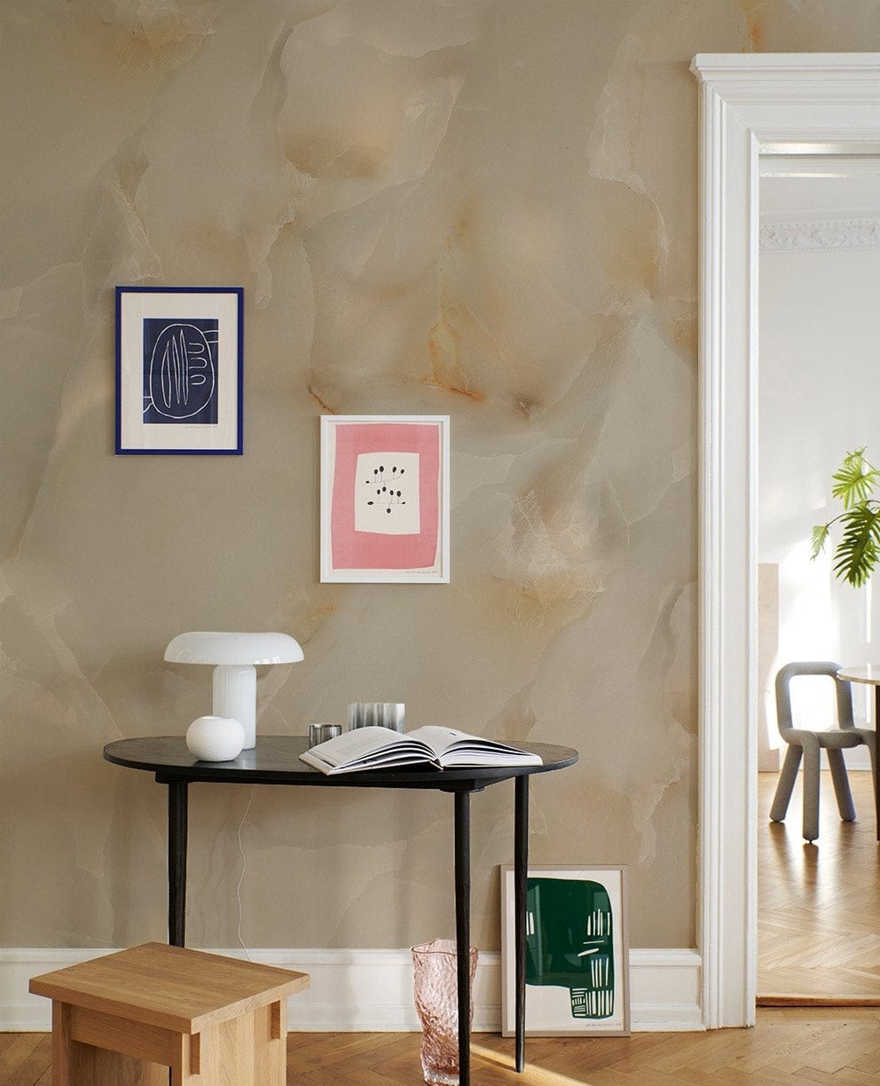 Elegant cream marble effect wallpaper, hallway setting, black console table, stylish wall art, wooden stool.