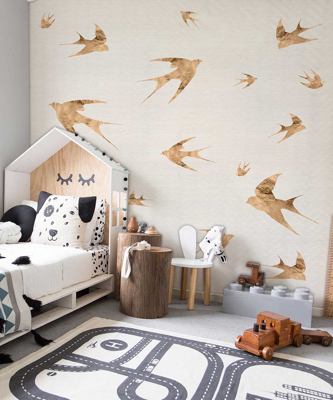 Children's room with rustic beige bird wallpaper, house-shaped bed, road rug, vintage toy truck.