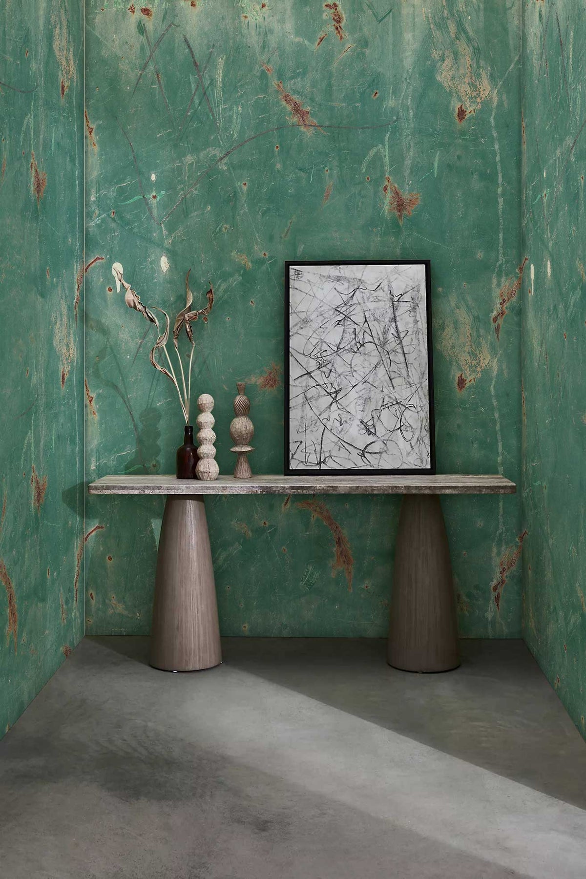 Teal distressed wallpaper, rustic chic room; features grey double pedestal table, artistic decor elements.