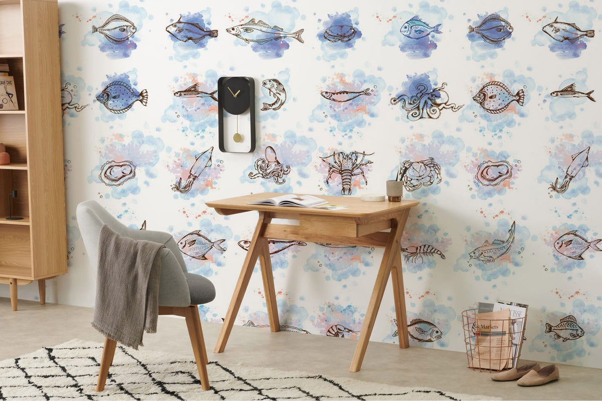 Hand-illustrated marine wallpaper in blue tones with wooden desk, grey chair, and modern room decor.