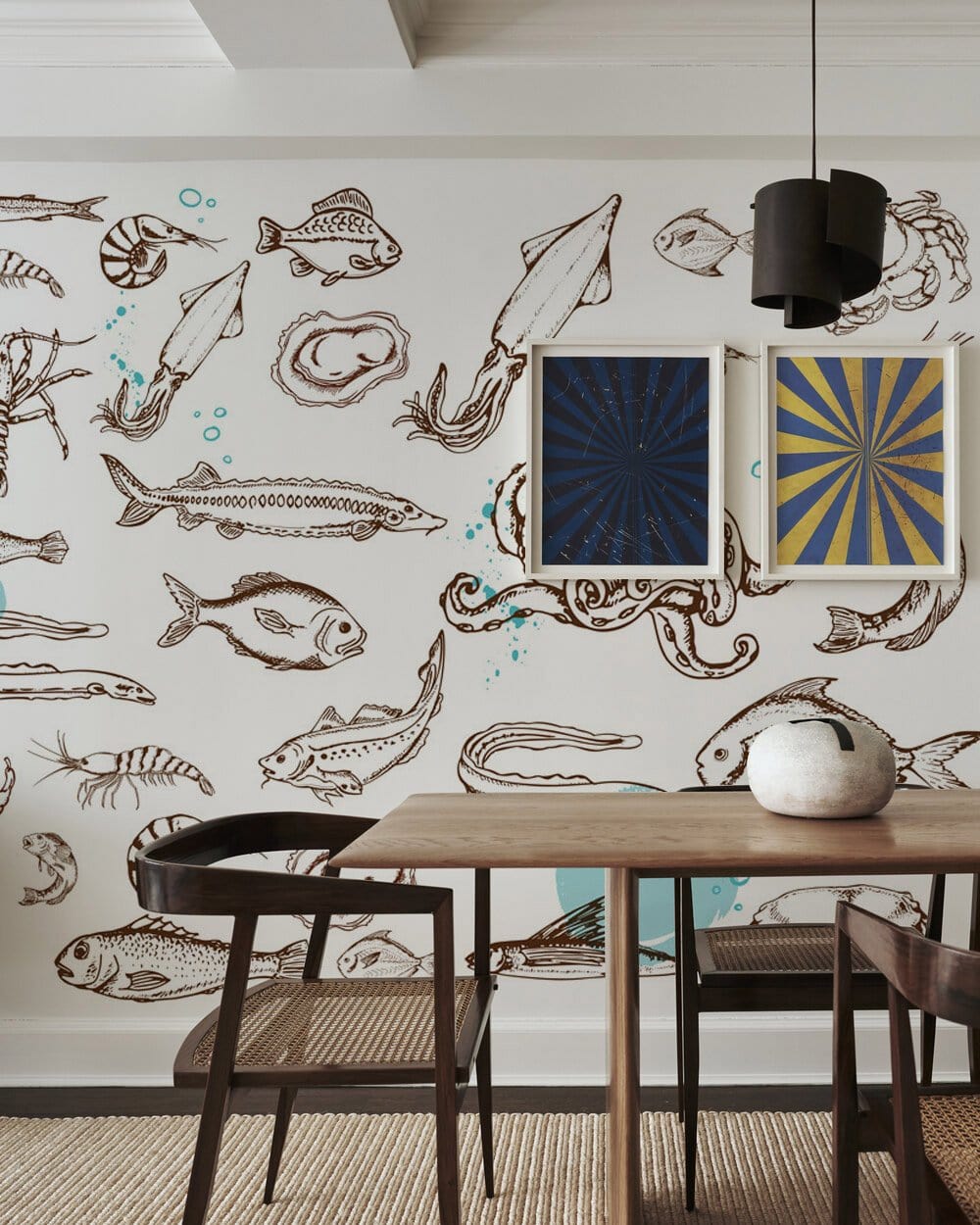 Nautical marine-themed wallpaper in dining room with wooden table, chairs, modern lighting, and framed artwork.