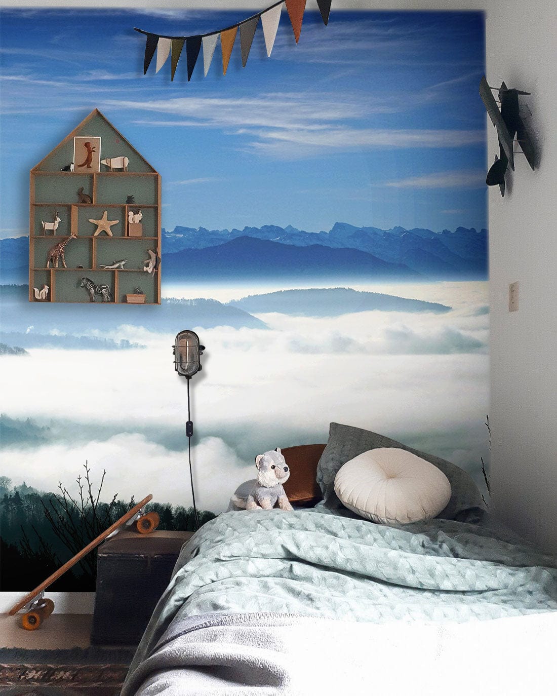 Children's room with Serene Mountain Mist Landscape Mural, plush toys, skateboard, and calming bedding.