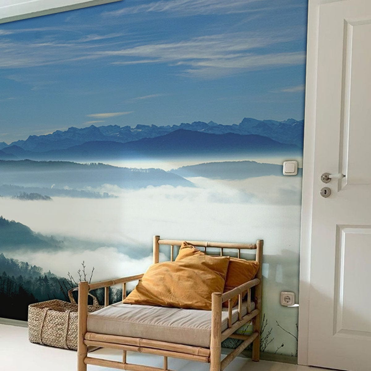 Serene Mountain Mist Landscape Mural Wallpaper in blue, calming room, wooden bench with mustard cushions.