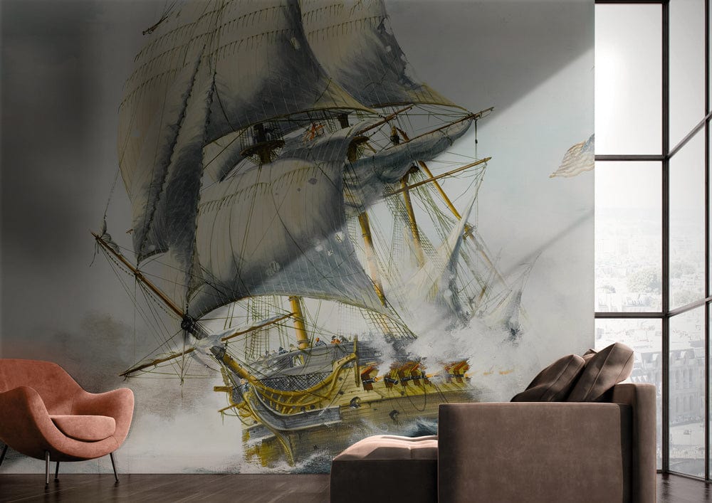 Vintage nautical ship mural wallpaper in white and blue, grey sofa, pink chair, hardwood flooring.