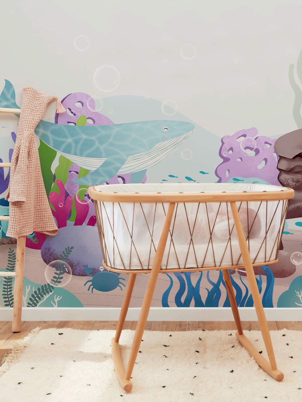 Children's Underwater Adventure Blue Whale Ocean Mural in nursery with wooden crib and soft rug.