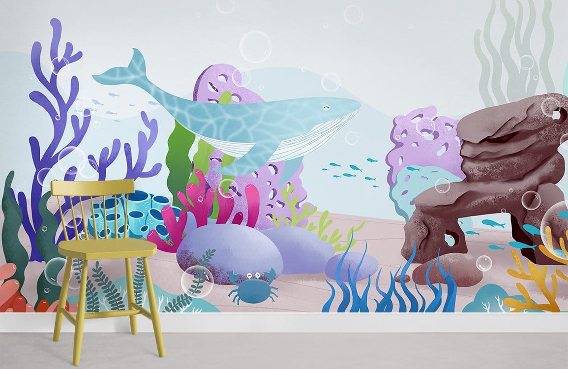 Children's underwater whale mural wallpaper in playroom with wooden chair, colourful ocean-themed decor.