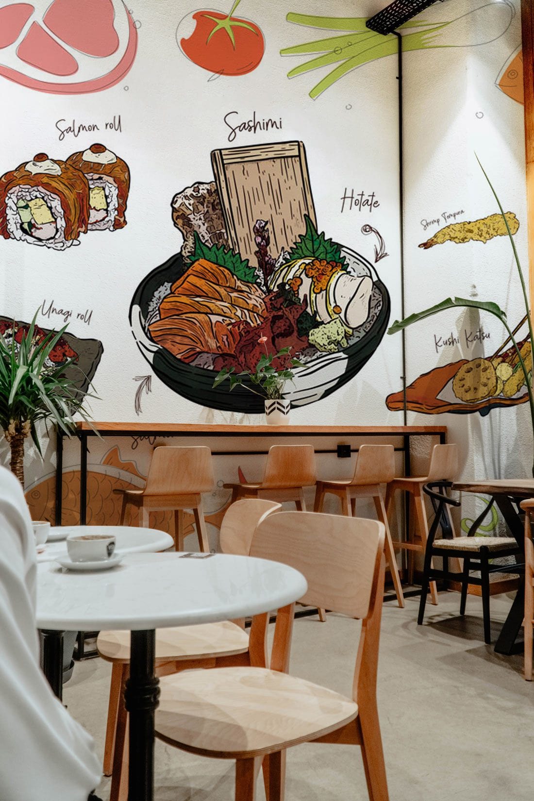 Sushi mural wallpaper in modern café with wooden chairs, grey floor, and a sushi-themed wall design.