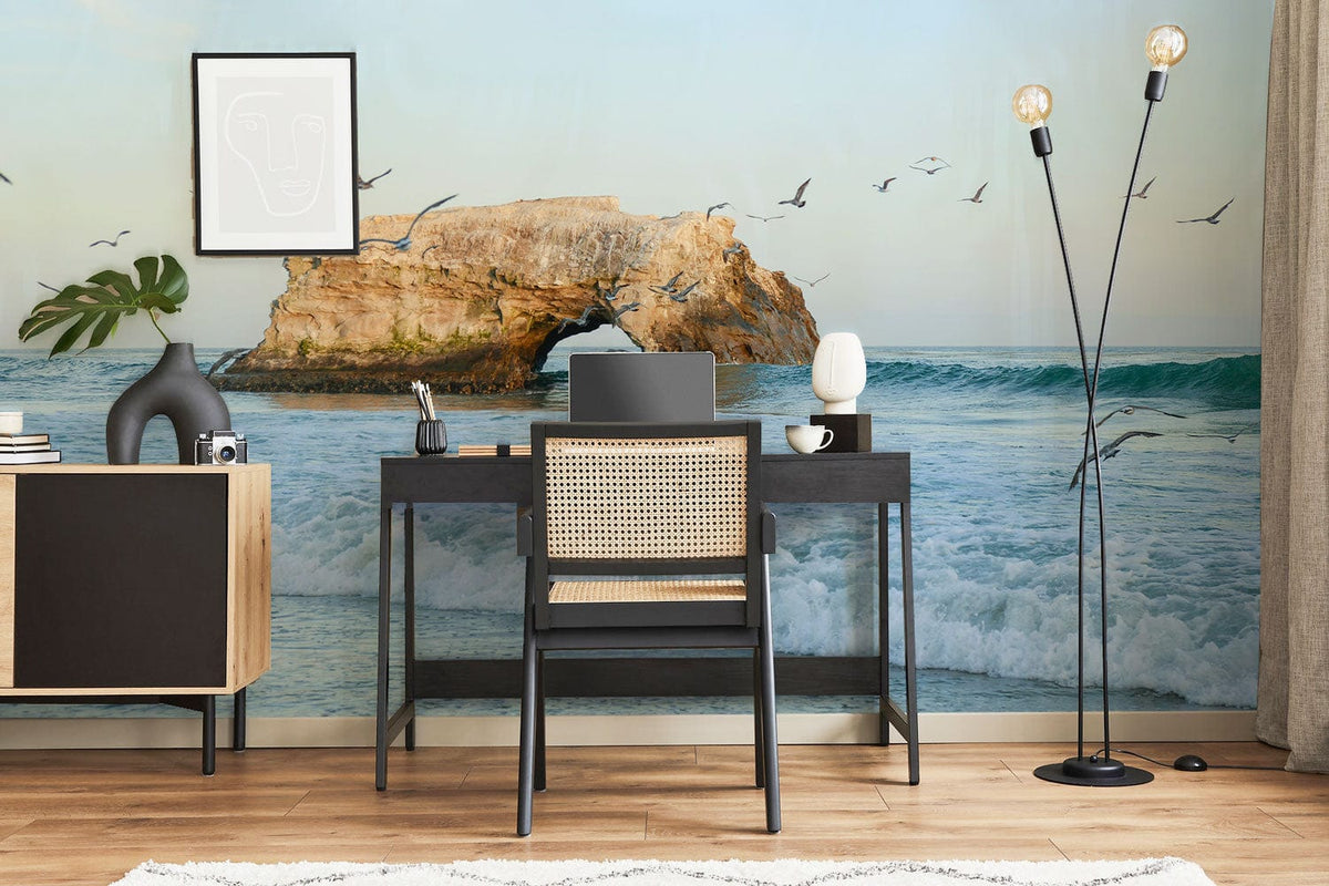 Modern office with Serene Coastal Seascape Mural Wallpaper, black desk, chair, standing lamp, wooden flooring.