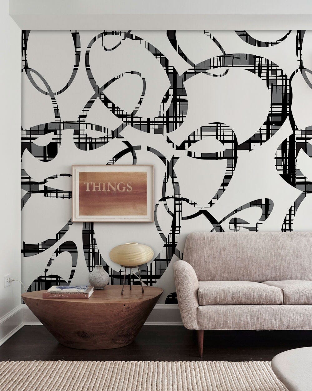 Monochrome swirl wallpaper in living room with beige sofa, wooden table, and dark flooring.