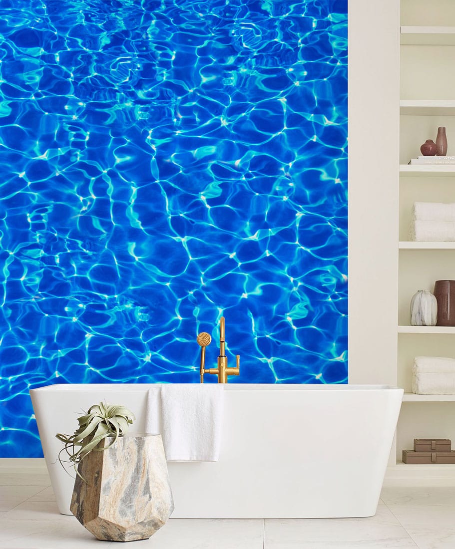 Elegant bathroom with vibrant blue rippling water effect wallpaper and modern freestanding bathtub.