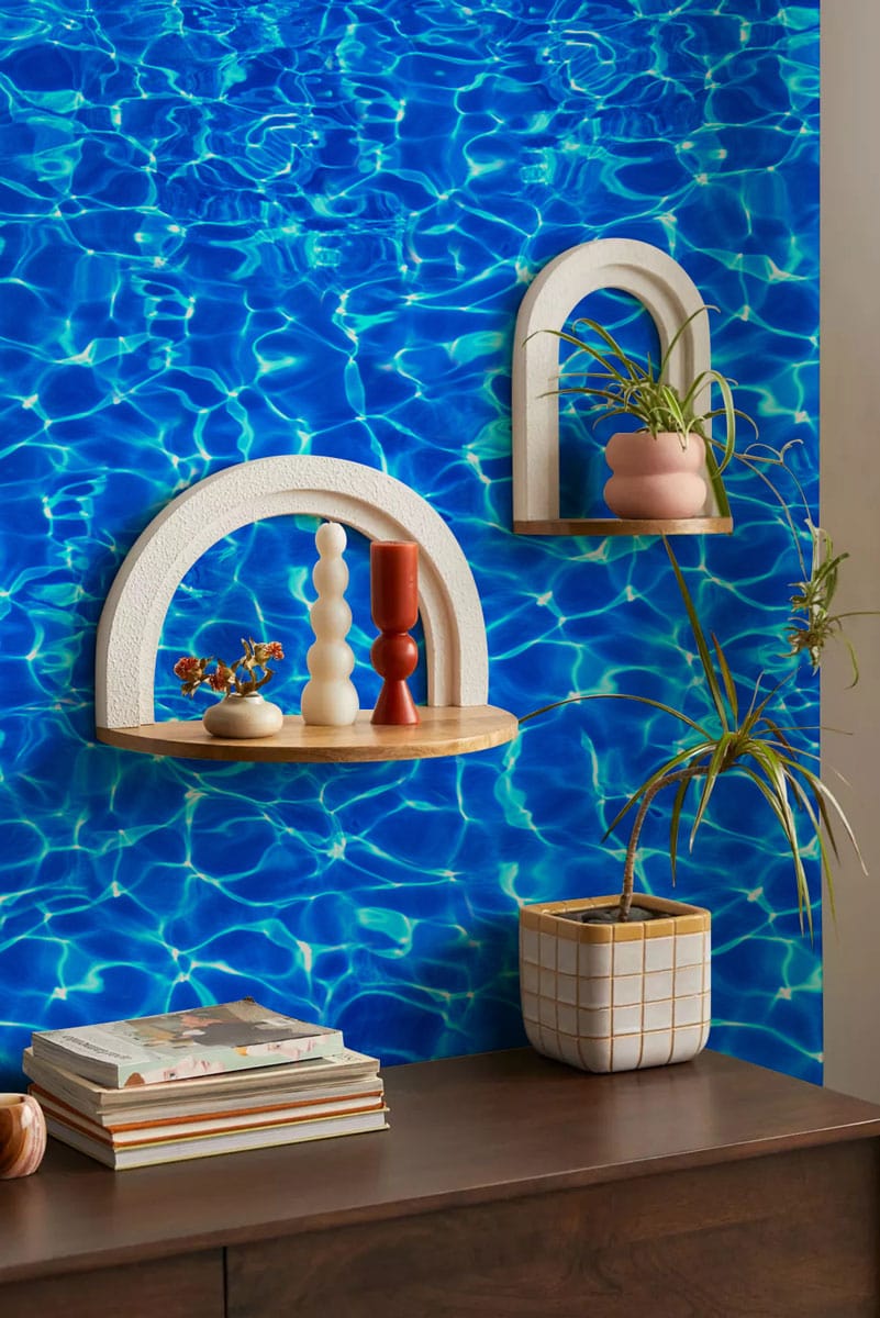 Vibrant blue water effect wallpaper with modern decor, wooden furniture, and stylish wall shelves.