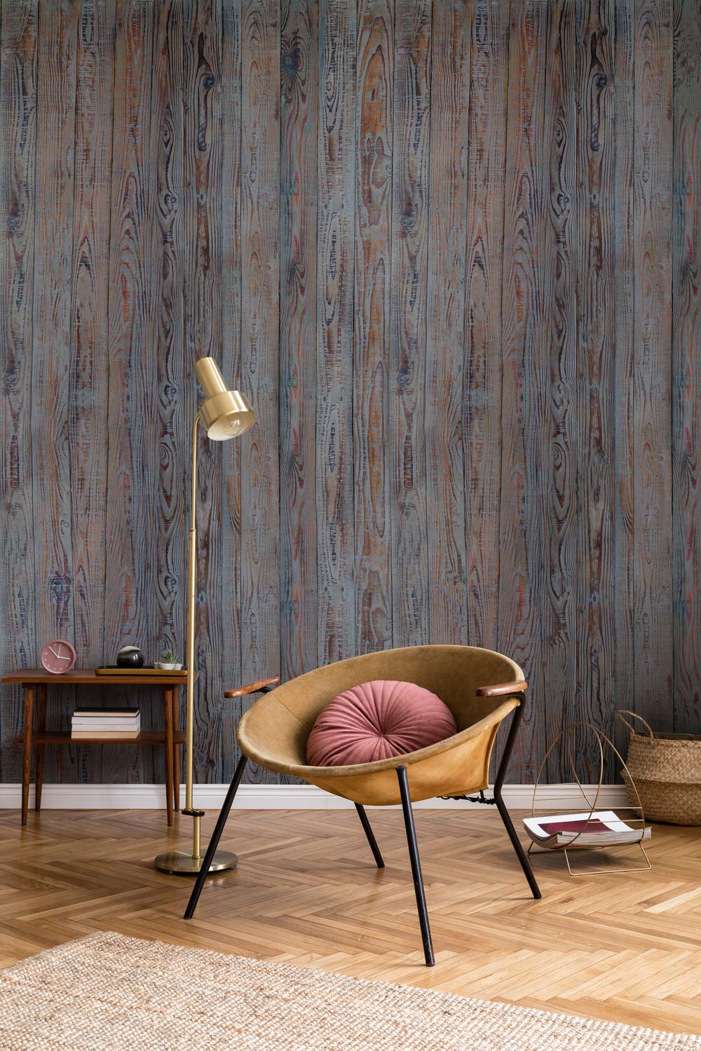 Rustic wood effect grey-brown mural wallpaper in living room, chair with cushion, wooden flooring.