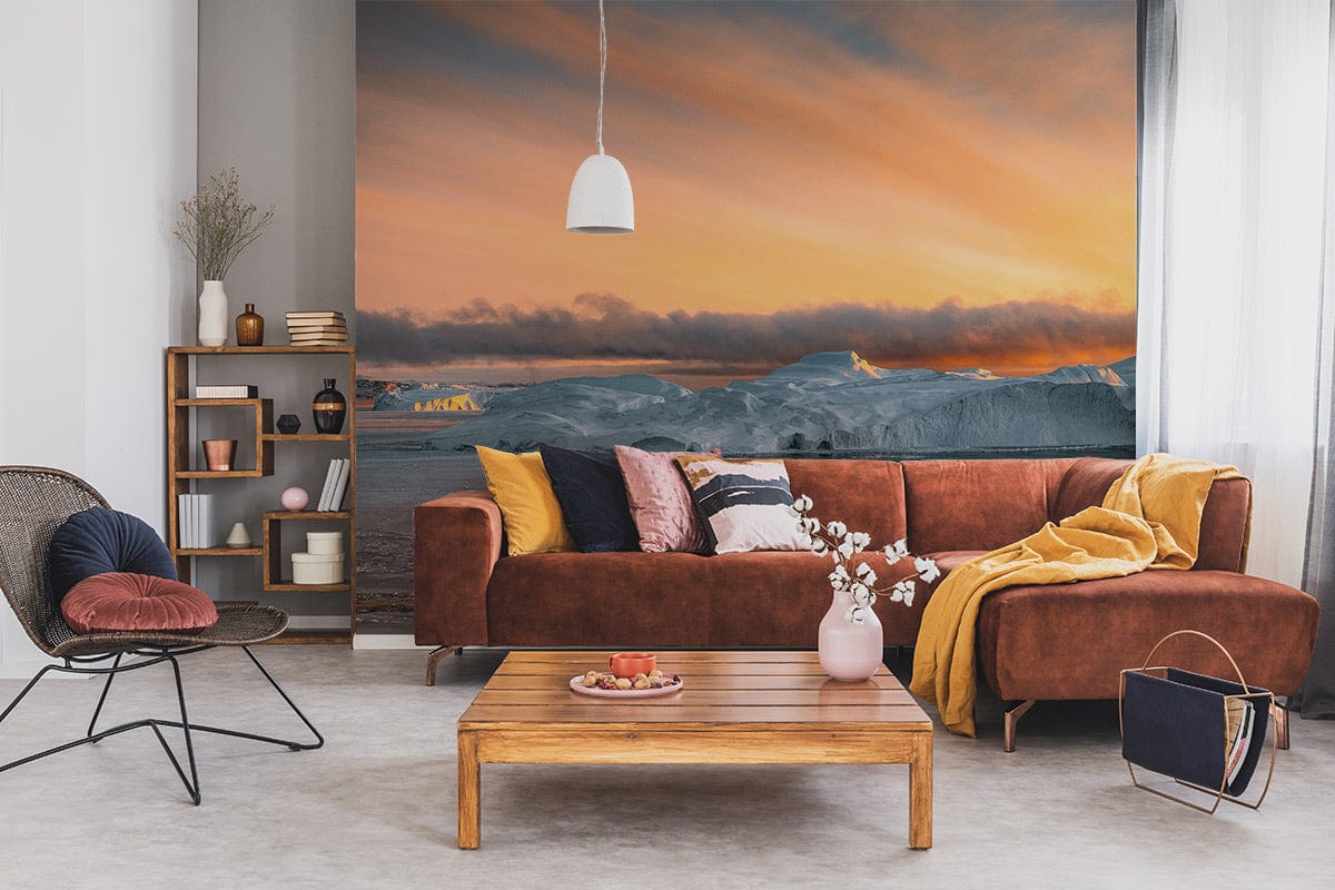 Sunset Arctic Ice Landscape Wallpaper in living room with orange sofa, grey flooring, wooden coffee table.