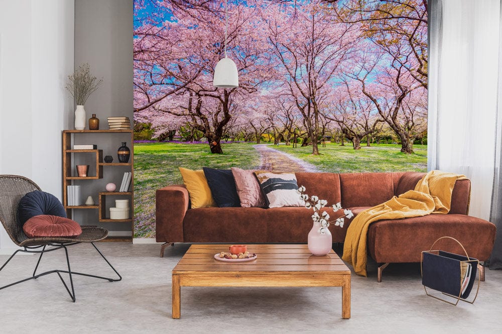 Brown sofa, grey wall, wooden table, pink spring landscape mural, Blossoming Cherry Grove Scenic Wallpaper.