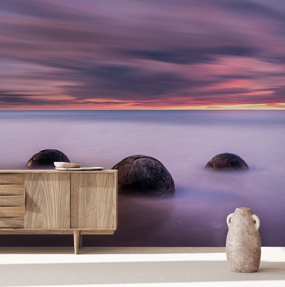 Ethereal Coastal Sunset Mural Wallpaper, serene purple ocean scene, wooden sideboard, vase, contemporary room.