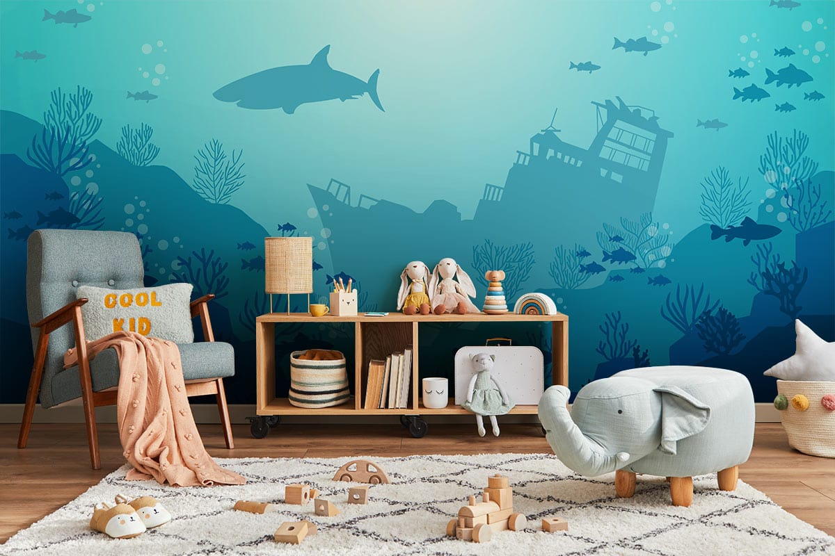 Underwater ocean adventure mural wallpaper in a children's playroom, featuring shipwreck design, blue chair.