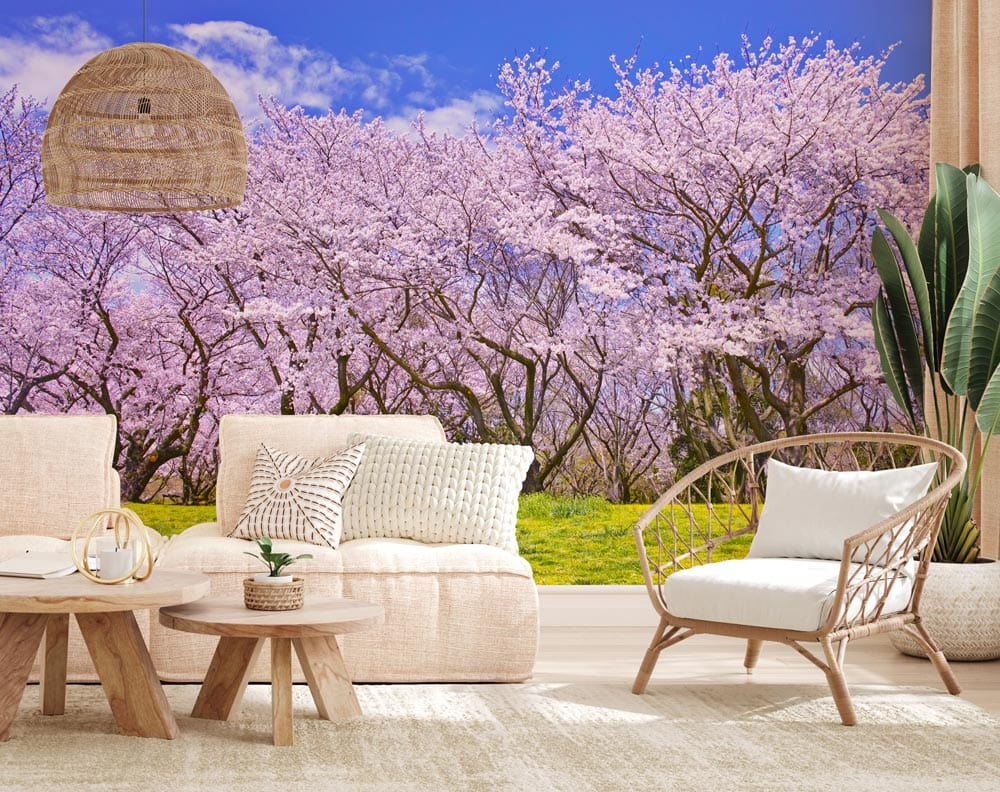 Elegant cherry blossom mural wallpaper, pink-green landscape, beige sofa, wicker chair, living room decor.